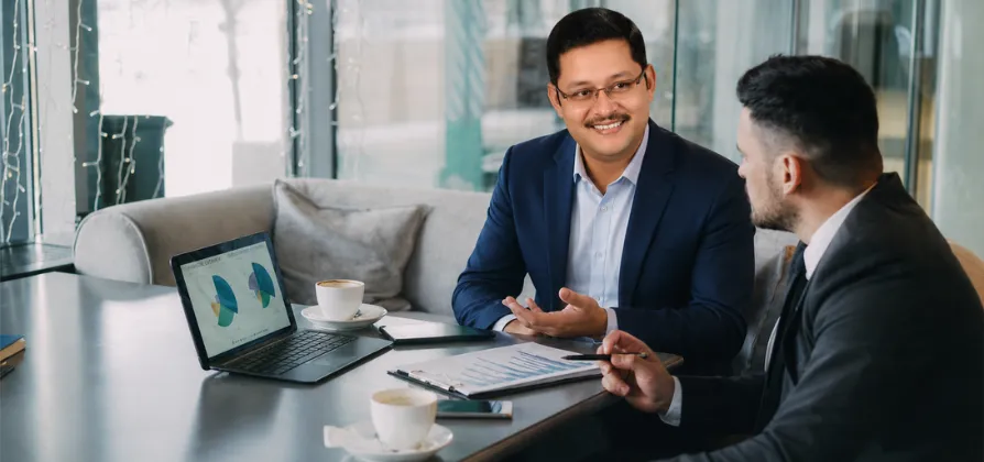 Confident businessman analyzing financial reports at his office desk.