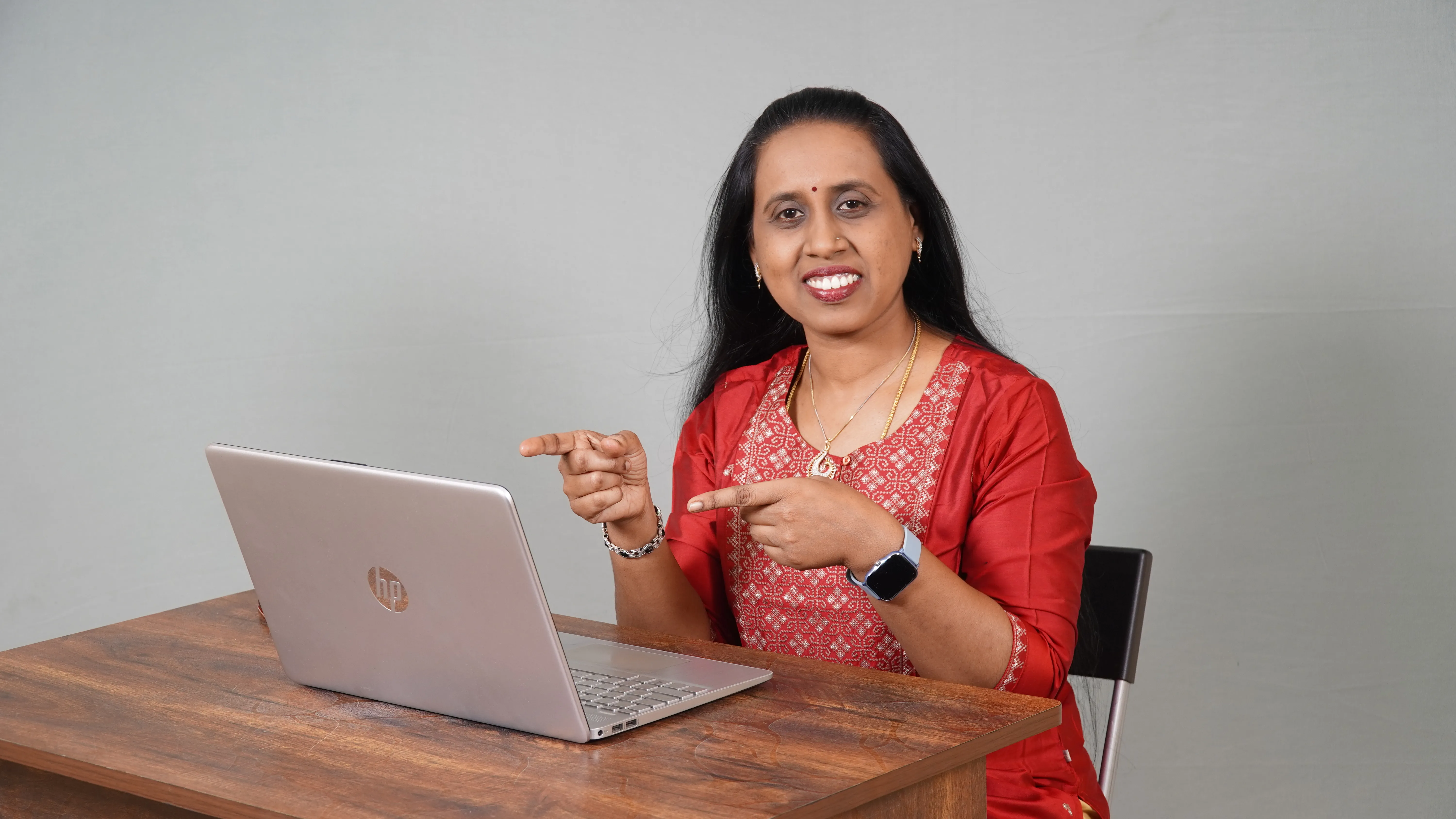 Woman in urban setting talking on phone, wearing casual attire, smiling.