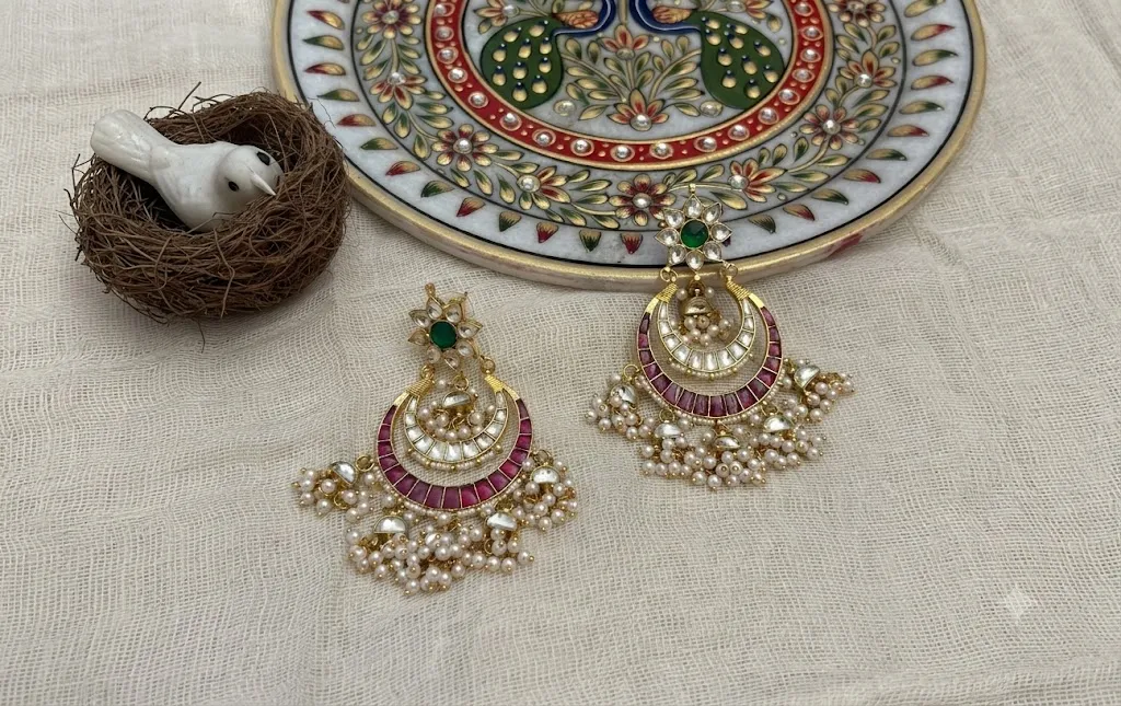 Luxurious Indian bridal jewelry with gold necklaces and bangles elegantly laid out on a rich red saree.