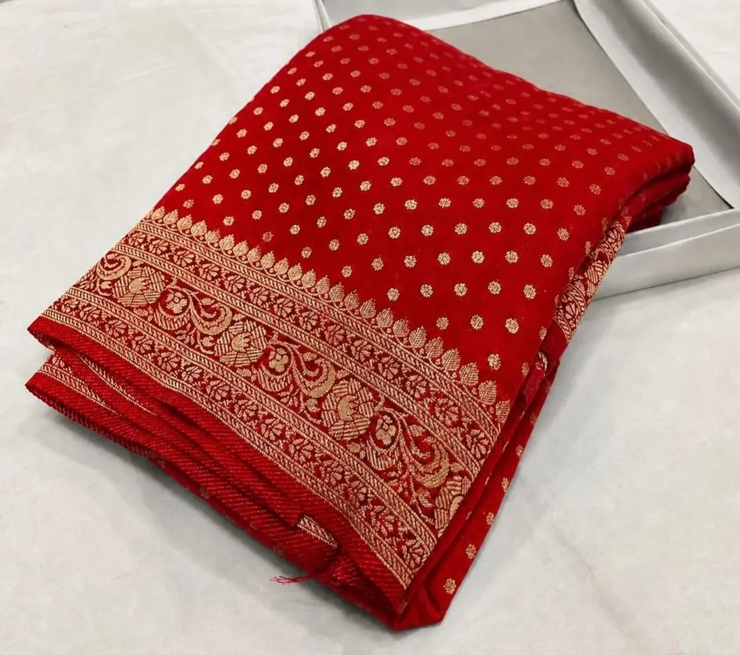 Woman in red saree with floral accessory walking outdoors.