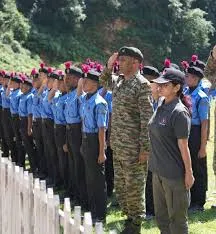 Group of Indian schoolgirls attentively listening in their classroom wearing uniforms.