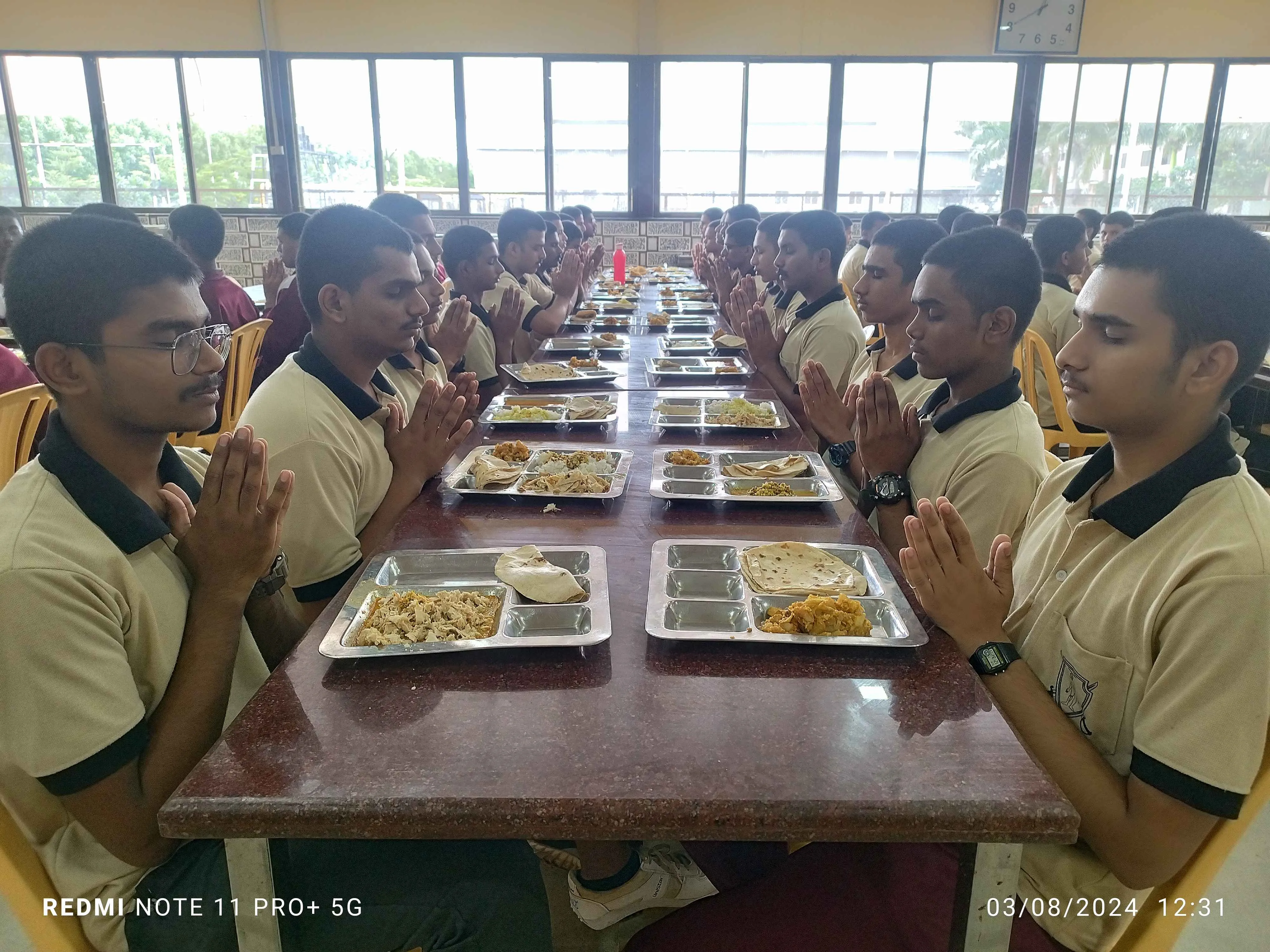 Students engaged in studying with open books, focusing on educational content in an outdoor setting.
