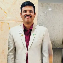 Young woman in gym sitting on chair, smiling confidently into camera.
