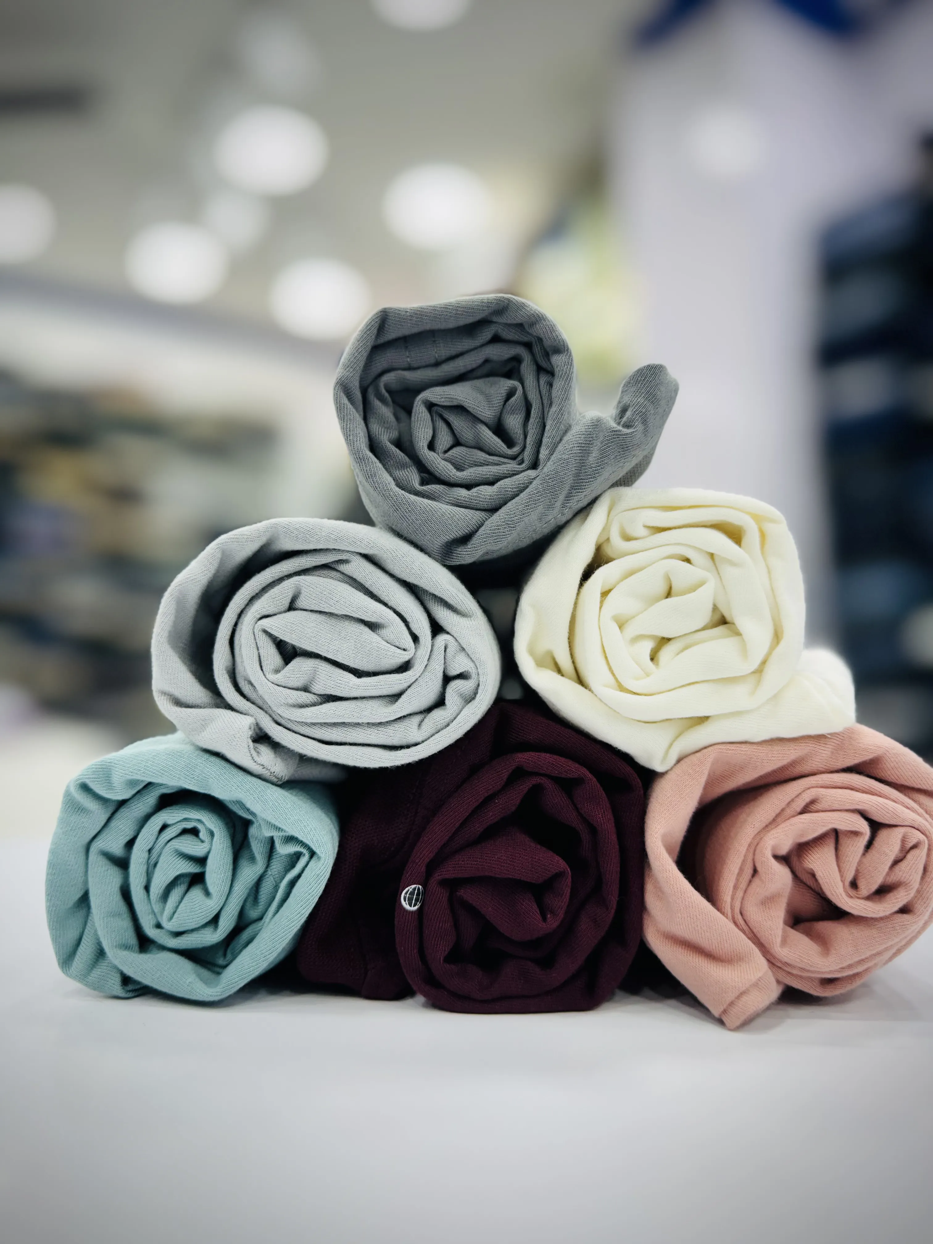 Three stylish polo shirts on a blue background with tropical shadow play.